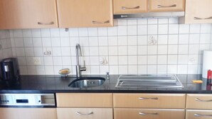 Een keuken met een vaatwasser, een spoelbak en een broodrooster.