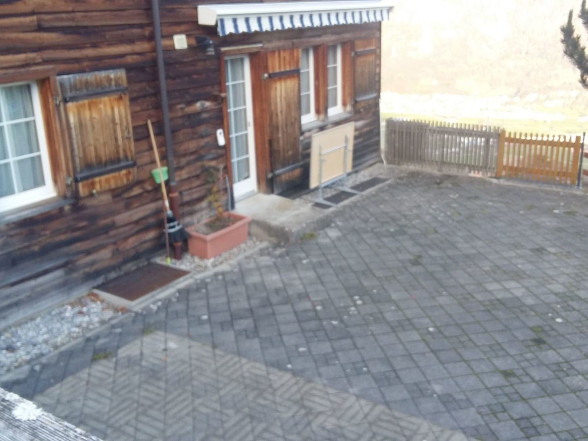 Ein Holzgebäude mit einem gepflasterten Innenhof.