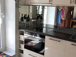 Eine Küche mit Arbeitsplatte, eingebautem Backofen und einer Schublade.