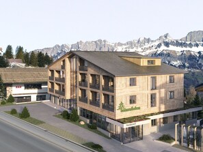 A multi-story wooden building with a restaurant sign, surrounded by mountains.