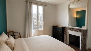 Ein Schlafzimmer mit Bett, Schminktisch, Spiegel und Kamin.