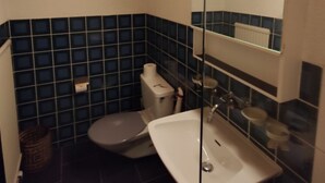 Un baño pequeño con inodoro, lavamanos y espejo.