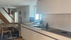 A modern kitchen with a wooden dining table, a built-in sink, and a window providing natural light. - Geelerhaus, (Berschis), by Interhome (Walenstadt)