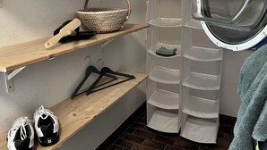 A laundry room with shelves, a basket, a drying rack, and a window. - Chriesilöser, (Bad Ragaz), by Interhome (Bad Ragaz)