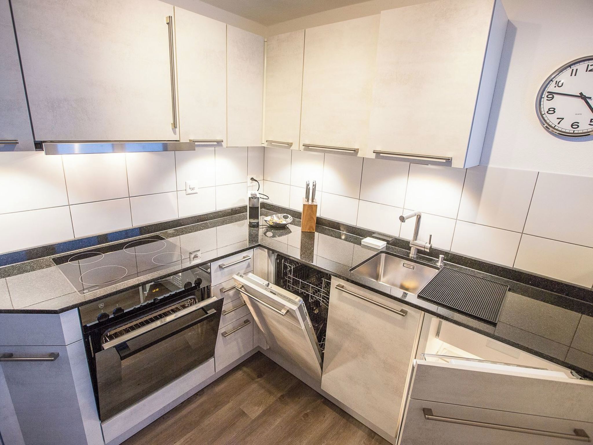 Een koelkast, een oven, kookgerei, borden en bestek