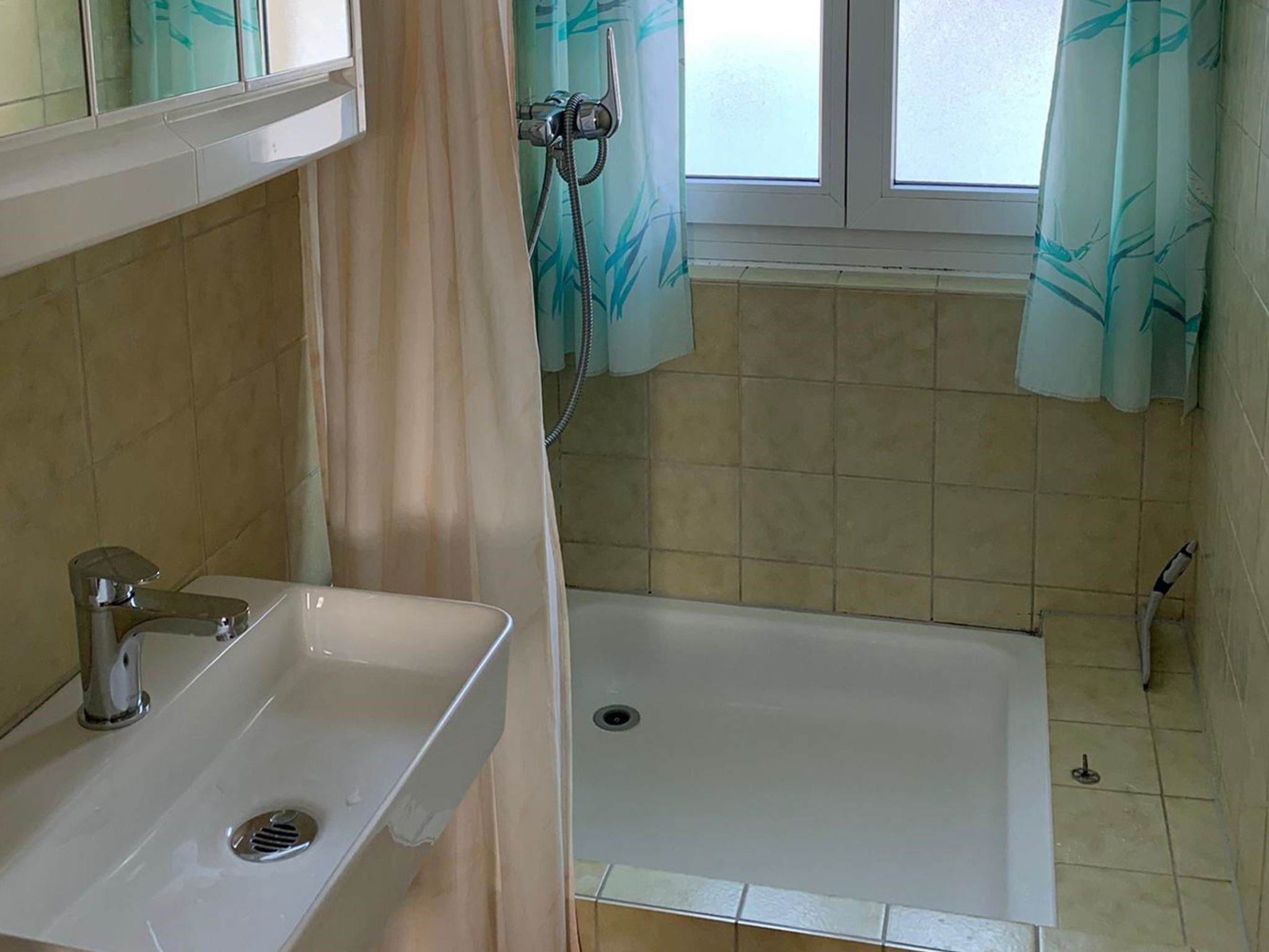 Een badkamer met een wastafel, een badkuip en een douche.