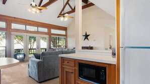 Una cocina moderna con microondas, armarios de madera y un ventanal grande.