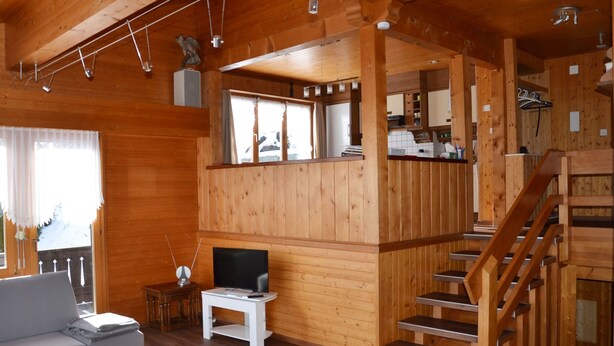 A wooden cabin interior with a living room, a TV, a staircase, and a kitchen area. - Chalet am Tobelbach, (Flumserberg Tannenheim), by Interhome (Flumserberg Tannenheim)