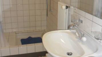 Ein Badezimmer mit einer Badewanne, einem Waschbecken und einem Spiegel.