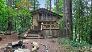 A cabin with a balcony, surrounded by a forest. - Woodland Home Near The Gorge - Private Deck 1 Bedroom Home (Washougal)