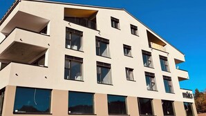 A multi-story building with a flat roof and large windows.