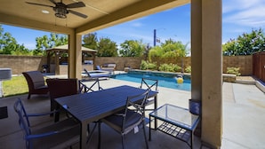 A covered patio area with a pool, outdoor furniture, and a ceiling fan. - Heritage Lake Luxury Home 4 Bedroom Home (Menifee)