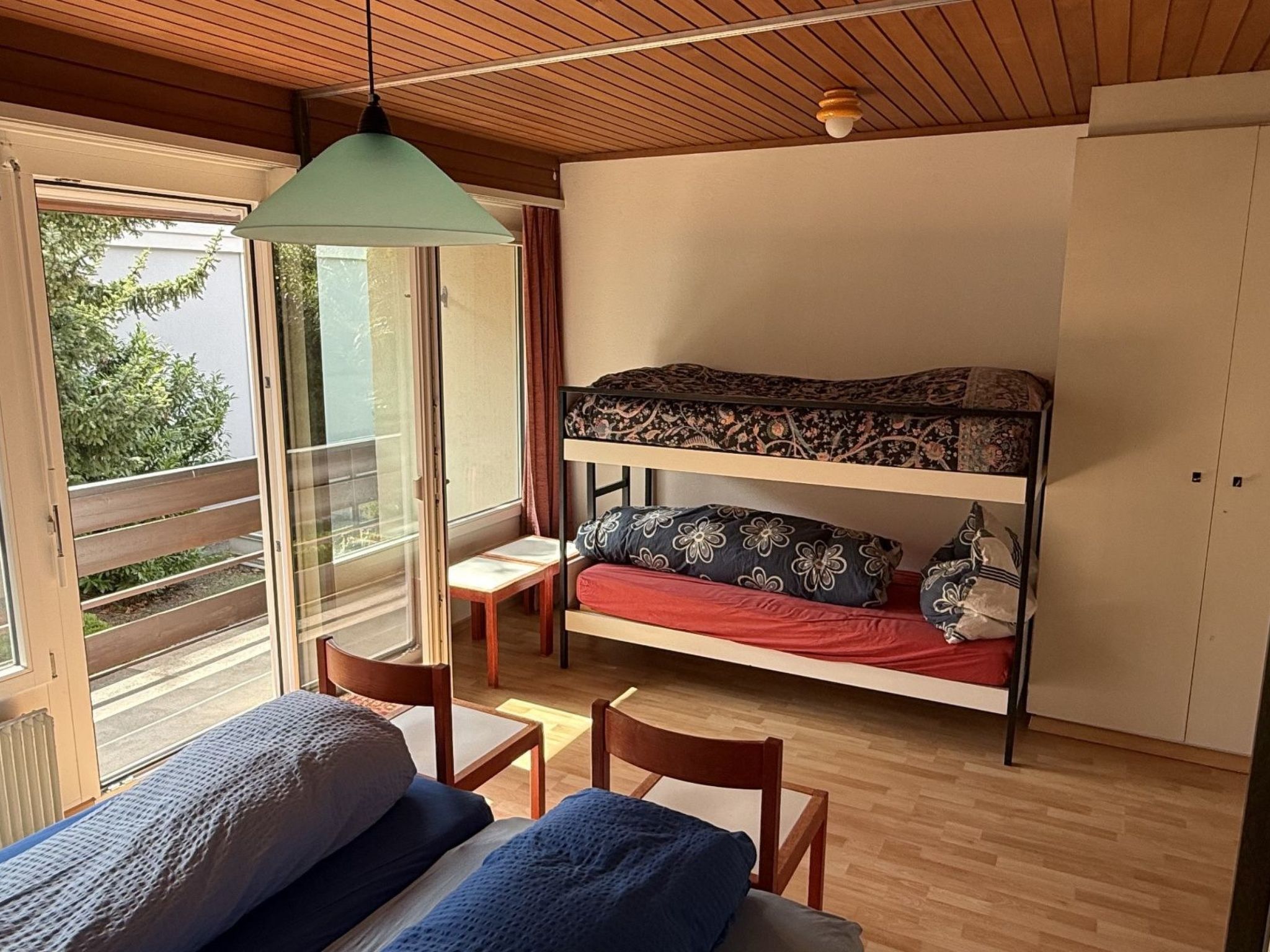Une chambre avec un lit superposé, un bureau et une chaise.