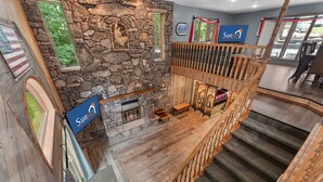 L’intérieur d’un hôtel avec une cheminée en pierre, un escalier en bois et un panneau indiquant la direction de l’hôtel Sunset Inn.