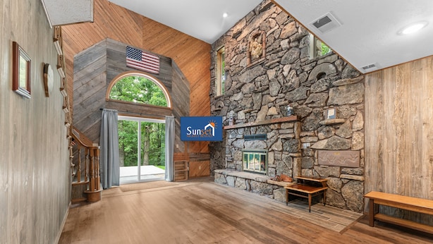 Un intérieur spacieux avec un mur en pierre, un plancher en bois, une cheminée et un drapeau américain.