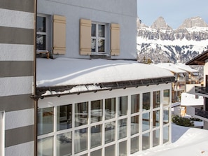A hotel with a snow-covered balcony, large windows, and a mountain view in the background. - Steinröschen, (Flumserberg Tannenboden), by Interhome (Flumserberg Tannenheim)