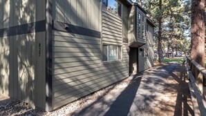 Un bâtiment à l’extérieur gris, avec le numéro « 827 » bien visible, et un chemin qui y mène.