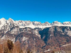 A mountain range with snow-capped peaks and a clear blue sky.