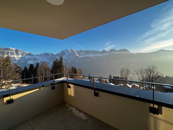 A balcony with a view of snow-capped mountains.