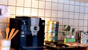 Et køkken med kaffemaskine, en dåse mad og en komfur.