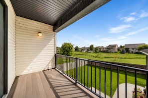Un balcon fermé offrant une vue sur un quartier résidentiel.
