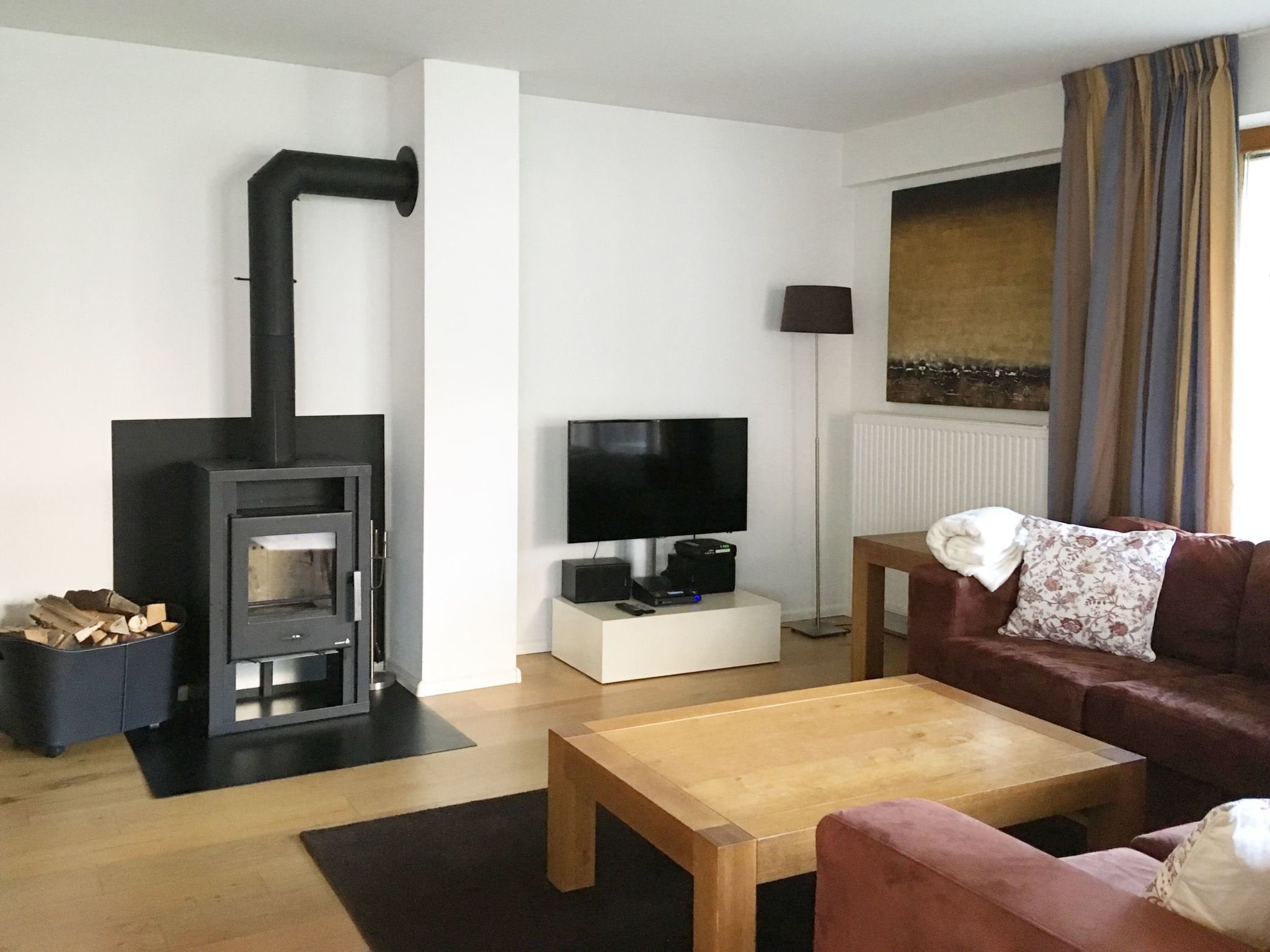 A living room with a fireplace, a television, a sofa, and a coffee table.