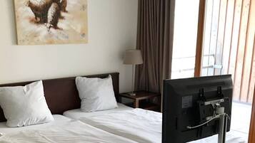 Une chambre d’hôtel avec un lit, une télévision, une lampe et un tableau au mur.