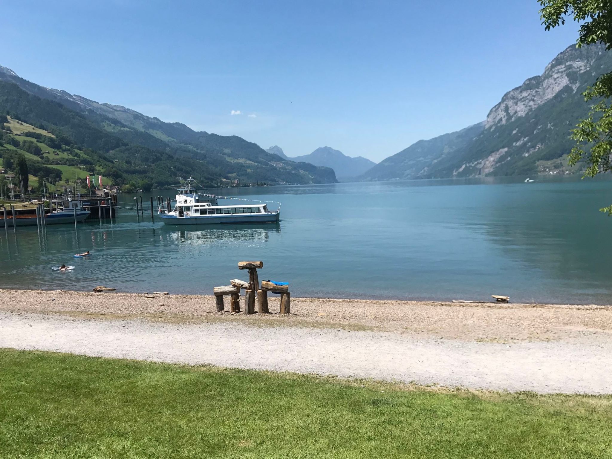 Un lac paisible, avec un bateau amarré au quai, entouré de montagnes.