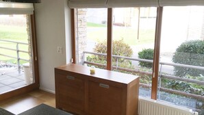 Una cocina con un mueble de madera, un ventanal con vista a un jardín y un radiador.