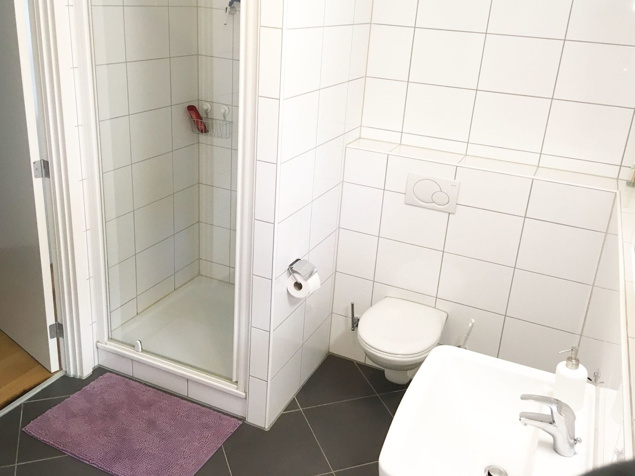 Un baño con ducha, inodoro y lavamanos.