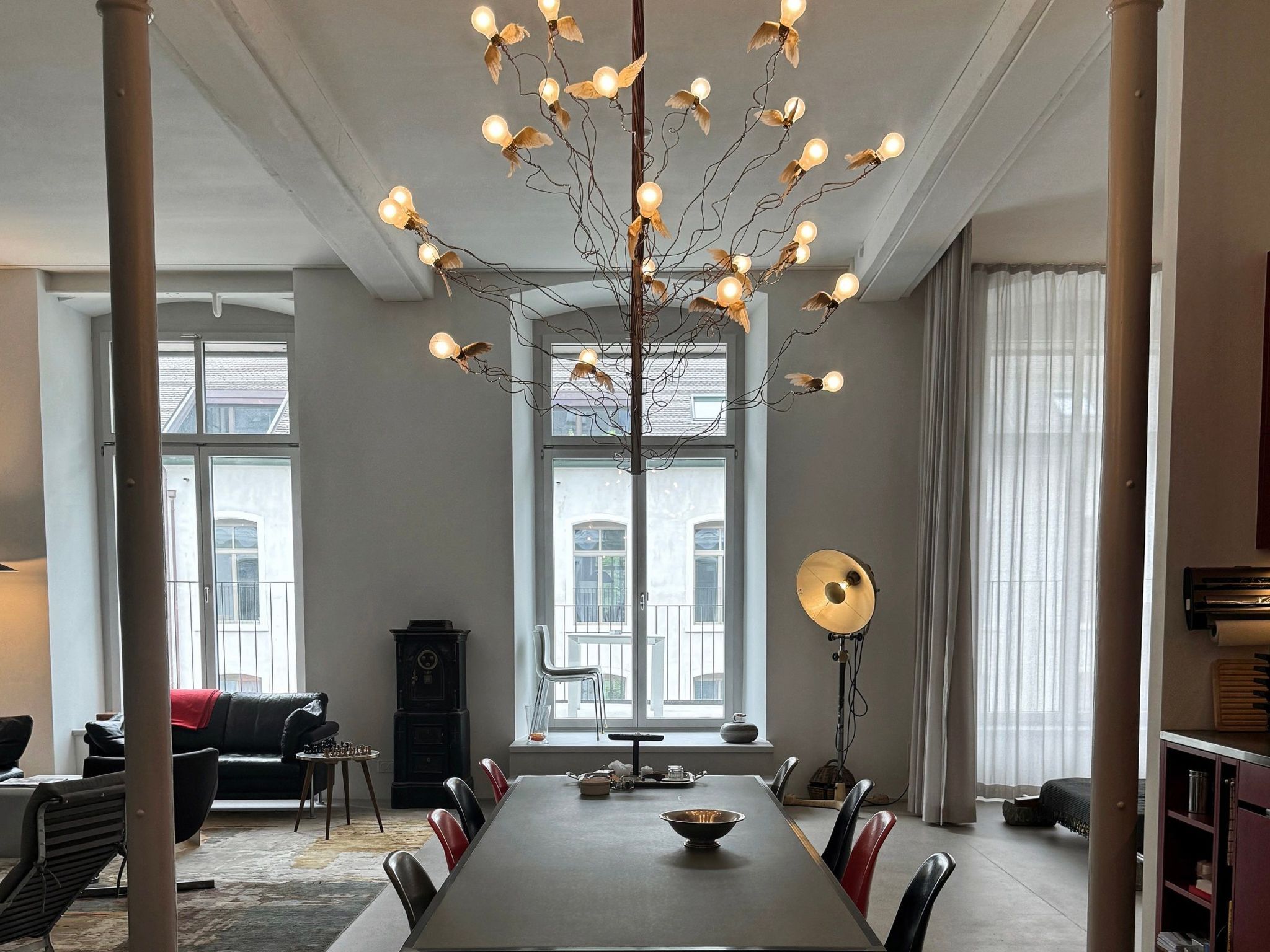 A spacious dining area with a long table, chairs, and a unique light fixture.