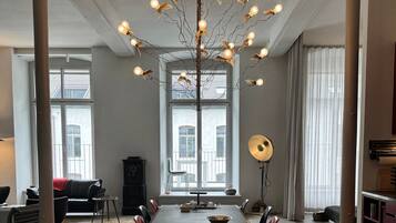 A spacious dining area with a long table, chairs, and a unique light fixture.