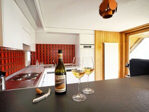 Una cocina moderna con una botella de vino y vasos sobre la encimera.