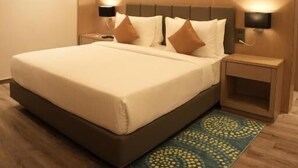 Une chambre d’hôtel moderne, dotée d’un grand lit, de tables de chevet et d’un éclairage d’ambiance.
