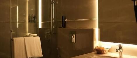 Un baño moderno con ducha envuelta en vidrio, lavamanos e inodoro.