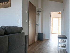 A modern living room with a sofa, a small table, and a door leading to another room. - Dachwohnung Tannenboden, Whg. Schmid, (Flumserberg Tannenboden), by Interhome (Flumserberg Tannenheim)