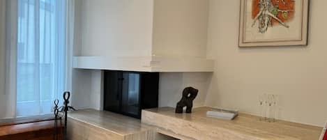 Una cocina moderna con horno empotrado, un comedor con encimera de mármol y una obra de arte enmarcada en la pared.