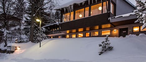 A modern building with large windows and a snow-covered roof.