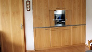 Una cocina con armarios de madera, una encimera y una puerta.
