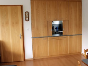 A kitchen with wooden cabinets, a countertop, and a visible stove.