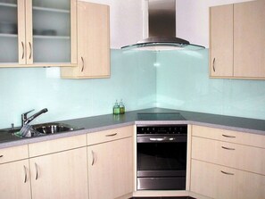 A kitchen with light-colored cabinets, a stainless steel sink, a stove, and a dishwasher. - Egglisboden, (Quarten), by Interhome (Mols)