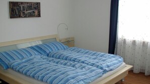 A single bed with a wooden frame and a headboard, a bedside table, and a wall-mounted artwork.