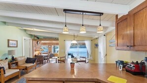 Amplia sala de estar con una mesa de comedor de madera, un sofá y una cocina con una isla grande.