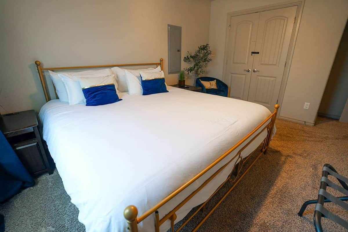 A bedroom with a bed, bedside tables, a chair, and a door.