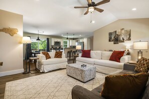 A living room with a sofa, coffee table, and a ceiling fan. - Bear Haven by Carolina Mornings | Pet-Friendly Cottage 12 Minutes From AVL (Weaverville)