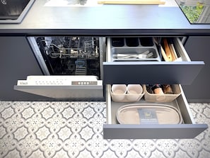 A kitchen drawer with a dishwasher, utensil holders, and storage baskets. - NEW Heritage Residence Hof Center (Hof)