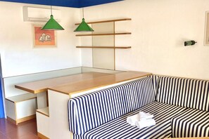 A modern room with a striped sofa, a wooden desk, and two pendant lights. - P.Rotondo1 A307 S SEA VIEW (Porto Rotondo)