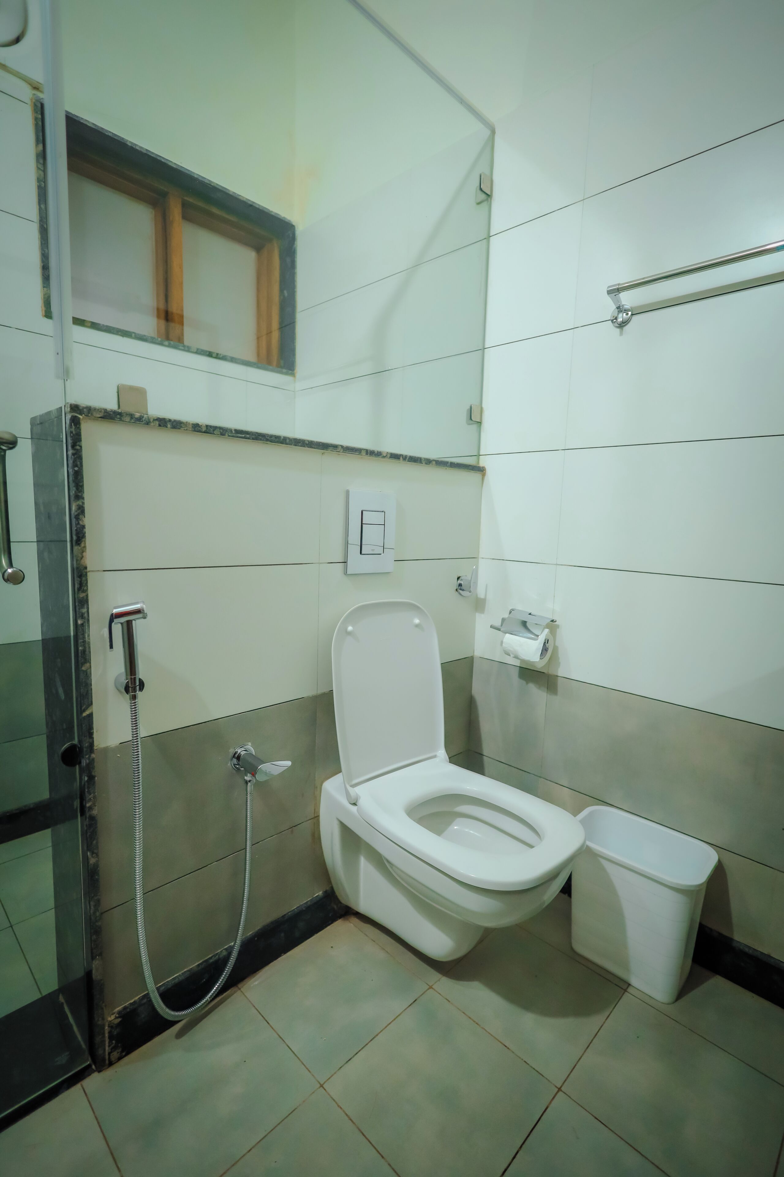 Une salle de bain équipée de toilettes, d’un sèche-mains et d’une douche à parois de verre.