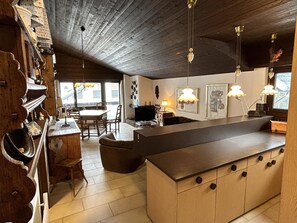 A spacious kitchen with a large island, wooden cabinets, and pendant lighting.