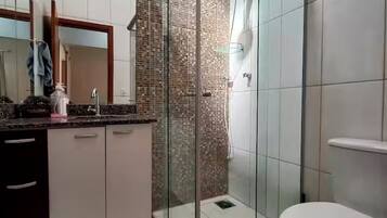 Chuveiro, secador de cabelo, toalhas de banho, papel higiênico